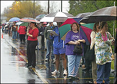 Hundreds of voters stand in line in the rain at the First Fellowship Church in Columbus, Ohio, in this Nov. 2, 2004, file photo.  Computerized voting was supposed to be the cure for ballot fiascos such as the 2000 presidential election, but activist groups say it has only worsened the problem and they've gone to court across the country to ban the new machines. (AP Photo/Mark Duncan, File)